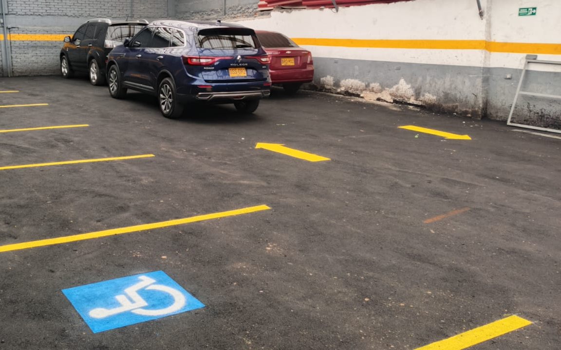 Parqueadero con demarcación amarilla y señal de accesibilidad